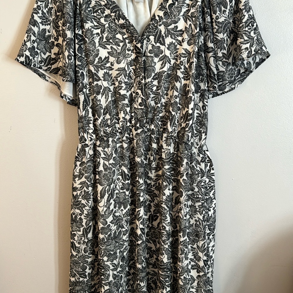 Flowery, black and white dress with floppy sleeves and matching belt.